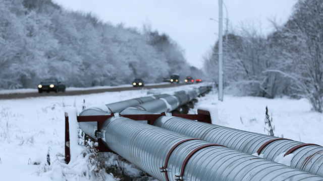 Natural gas pipelines in snowy field. 