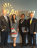 Group of four Ameren employees standing in front of the Ameren sign. 